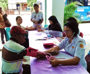 Perawat Yuniyati Abineno, Amd. Kep. dan Sri Herlin Ernawati, S. Kep. Ns. sedang melakukan pemeriksaan kesehatan sederhana di Posyandu Lansia Pniel I