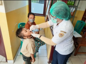 Petugas Gizi Petronela Hamid sedang memberikan Vitamin A pada Balita di Pustu Fatululi