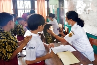 Perawat Helena Hani, S.Kep, Ns sedang Melakukan Pemeriksaan Kesehatan Anak Sekolah